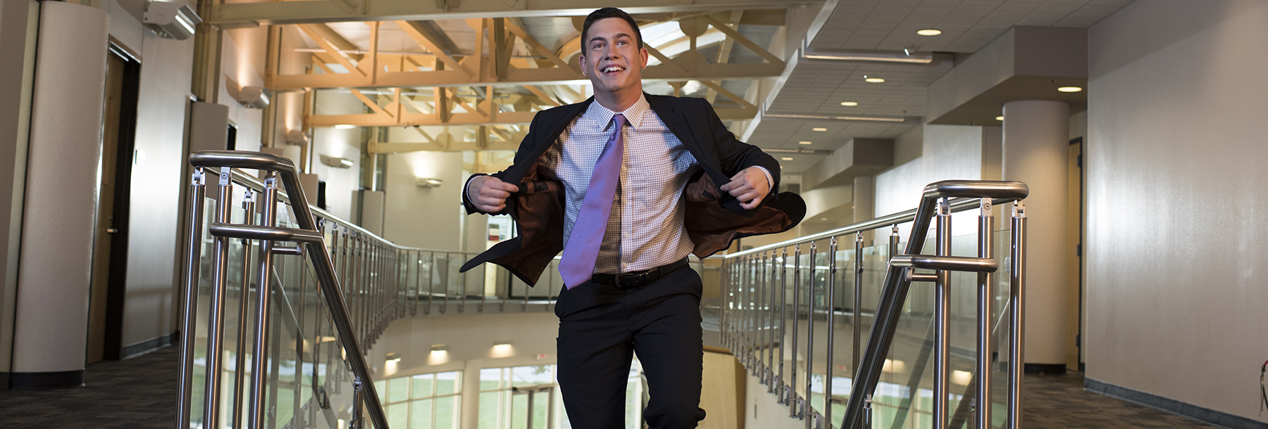 Section Image: Student in a suit coming up the stairs in Smith Hall. 