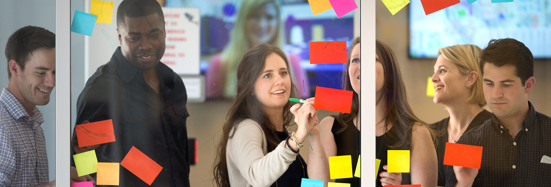 Section Image: Stacy Grau and students with post-it notes 