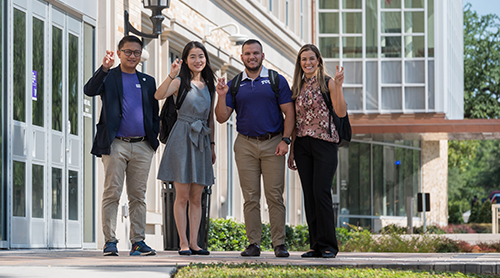 Section Image: Four students walking down the stairs outside the Neeley Business Commons 