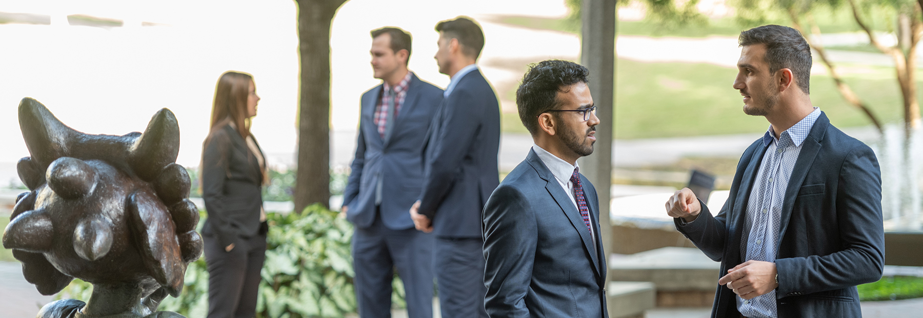 Section Image: Students conversing by statue of Superfrog 