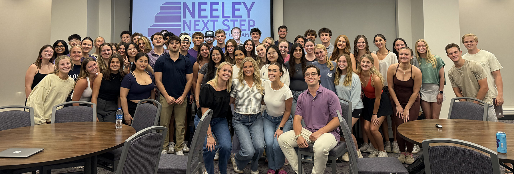 Section Image: Group of students in front of a projector showing Neeley Next Step 
