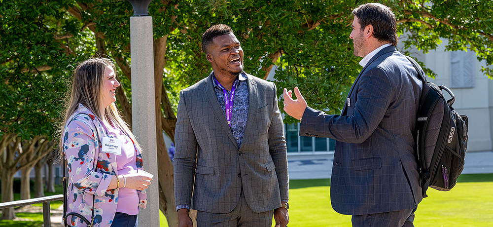 Section Image: Three people on the TCU campus talking together 