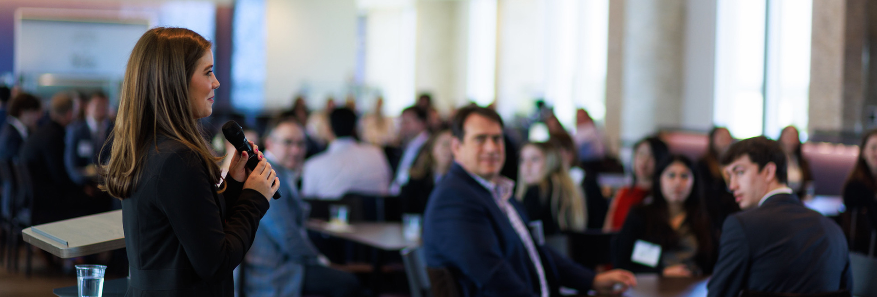 Section Image: Female student addresses a group of mentors and mentees 