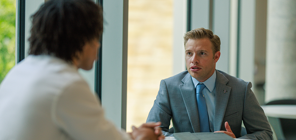 Neeley 2nd floor atrium two students talking