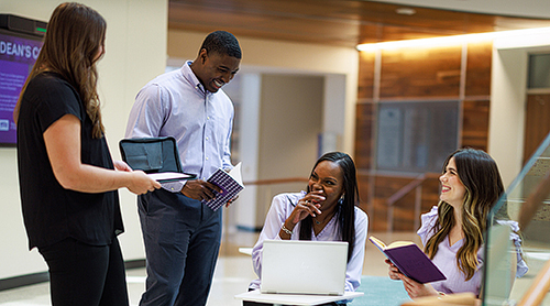 Michelle Franklin laughs with a group of students in the Rotunda