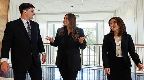 Three people walking on the second floor of Hays Hall