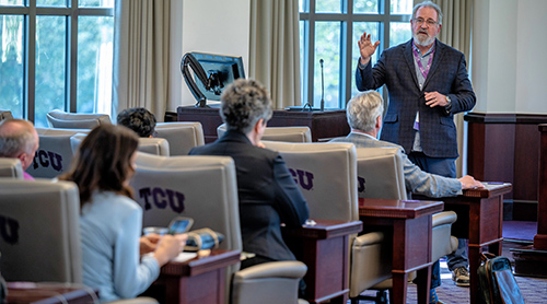 Professor teaching in front of group 