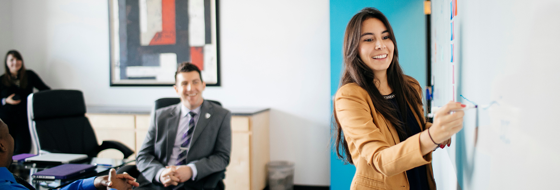 Section Image: Woman writing on a white board 