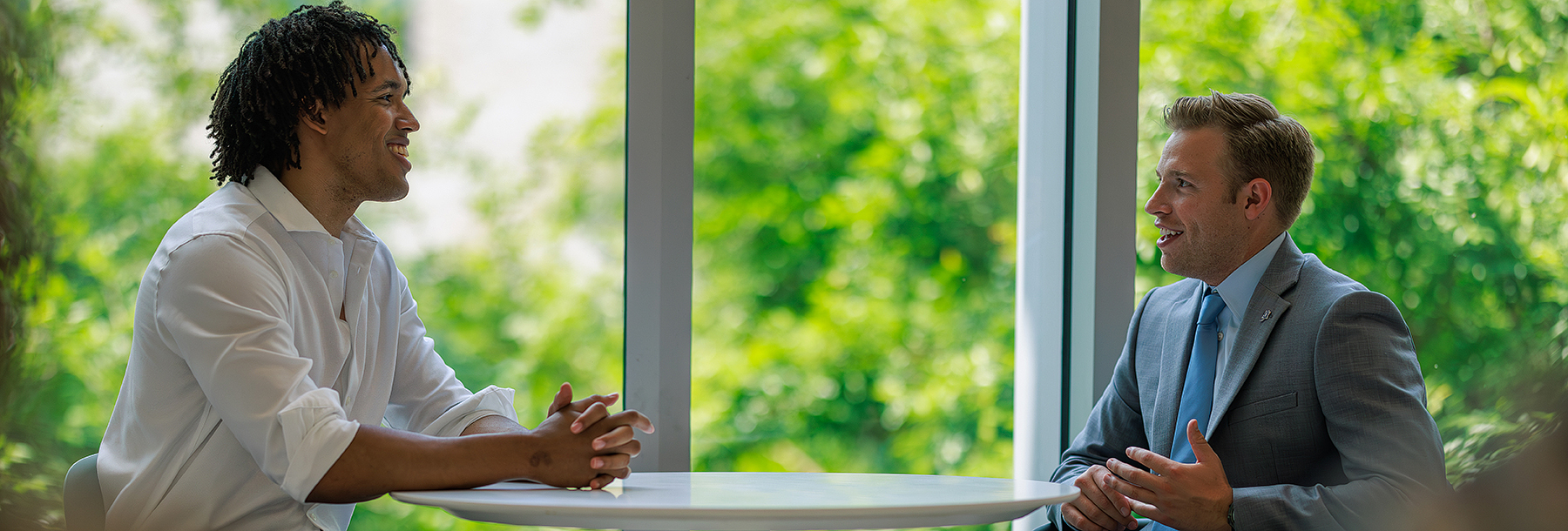 Section Image: Two students at a round table in the Hays Business Commons 