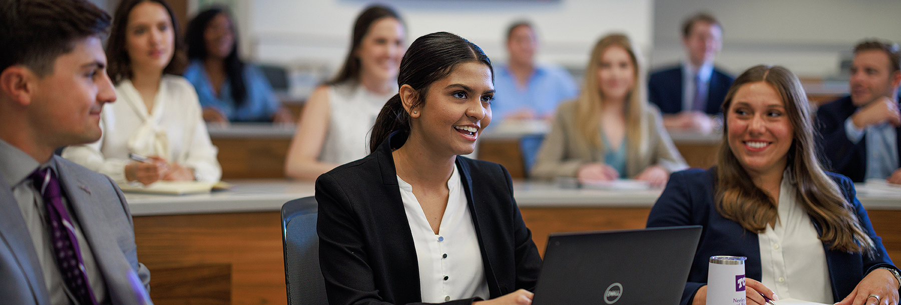 Section Image: Students in suits seated in a tiered classroom 