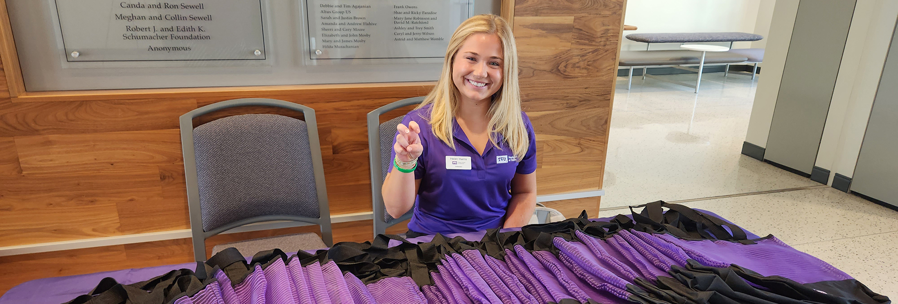 Section Image: Student with a table full of bags to hand out to families 