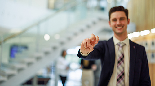 Section Image: Neeley student by the grand staircase 