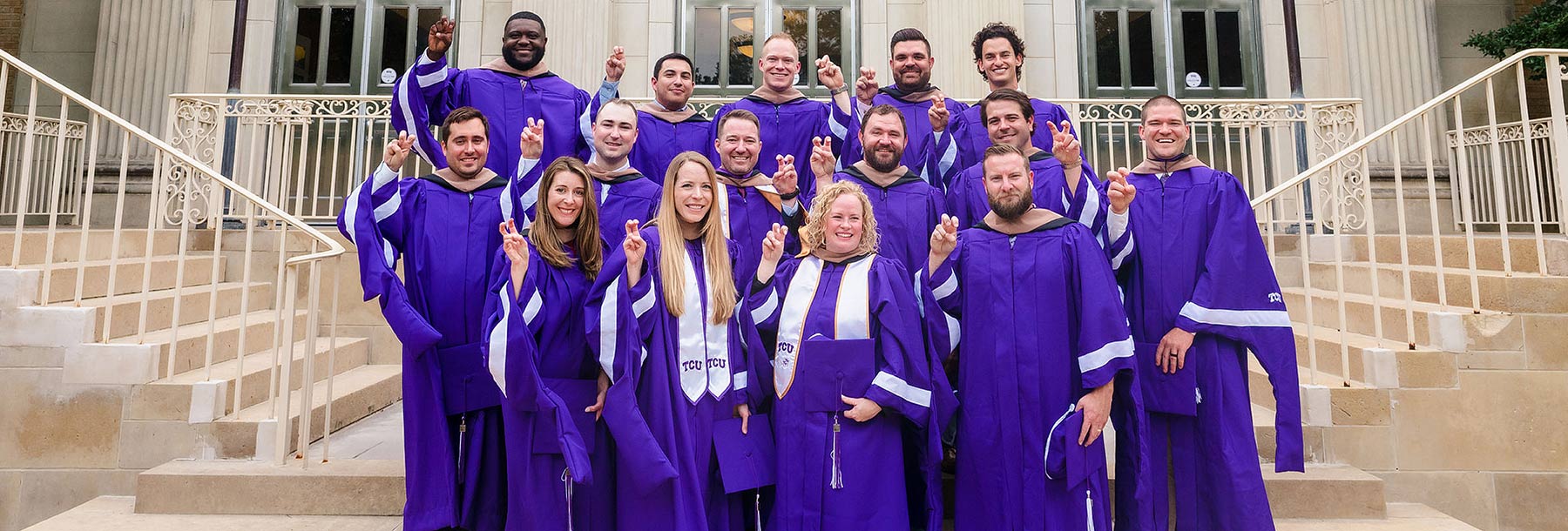 Section Image: Energy graduates in cap and gown on the steps of Ed Landreth Hall 