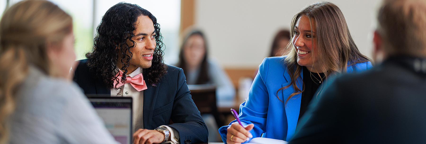 Section Image: Students at a table working in groups 