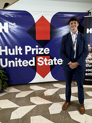 Forrest Williams in front of a banner that says Hult Prize United States