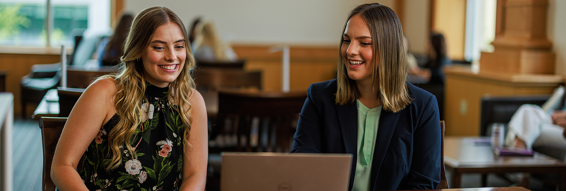 Section Image: Two girls at a table looking at a laptop 